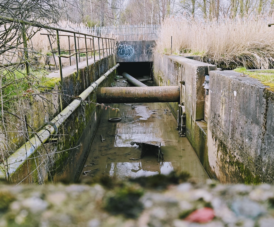Concrete channel with pipes and murky water